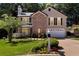 Charming two-story home featuring a manicured lawn, brick accents, and an attached two-car garage at 1481 Howard Way, Lawrenceville, GA 30043