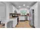Well-lit kitchen featuring stainless steel appliances, light wood floors, white cabinetry, and granite countertops at 1481 Howard Way, Lawrenceville, GA 30043