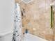 Bathtub and shower features ceramic tile surround with shower caddy and neutral paint at 1481 Howard Way, Lawrenceville, GA 30043