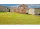 View of a spacious backyard with a well-kept lawn, and a brown house exterior at 2397 Planters Cove Dr, Lawrenceville, GA 30044
