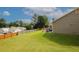 Large backyard featuring an expansive green lawn, patio furniture, and a wooden fence at 2397 Planters Cove Dr, Lawrenceville, GA 30044