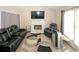 Inviting living room featuring a cozy fireplace, large window, and a comfortable leather furniture set at 2397 Planters Cove Dr, Lawrenceville, GA 30044
