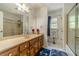 Bathroom featuring a long vanity with double sinks and a glass door shower/tub combination at 4989 Woodfall Sw Dr, Lilburn, GA 30047