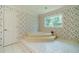 Bathroom with a large tub, floral wallpaper, and tile flooring at 4989 Woodfall Sw Dr, Lilburn, GA 30047