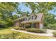 Brick home with lush landscaping, mature trees, and a well-manicured lawn at 4989 Woodfall Sw Dr, Lilburn, GA 30047