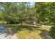 Brick home with a beautifully landscaped front yard and mature trees at 4989 Woodfall Sw Dr, Lilburn, GA 30047