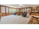 Large living room with carpet, built-in shelves, and accent paneling at 4989 Woodfall Sw Dr, Lilburn, GA 30047