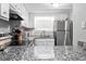 Bright kitchen with granite countertops, stainless steel appliances, and ample cabinet space at 102 Oak Pl, Villa Rica, GA 30180