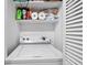 Convenient laundry area with a white washing machine and upper shelving at 102 Oak Pl, Villa Rica, GA 30180