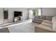 Bright living room featuring a comfortable sectional sofa, large TV, and sliding glass doors at 102 Oak Pl, Villa Rica, GA 30180