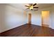Bright bedroom with dark hardwood floors, ceiling fan, and two open doorways at 2285 Peachtree Ne Rd # 1202, Brookhaven, GA 30309