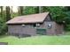 Rustic home exterior with unique window designs and a covered foundation, surrounded by greenery at 4567 Town Crier Sw Rd, Lilburn, GA 30047