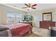 Cozy bedroom with neutral walls, a ceiling fan, and natural light from the large window at 12303 Waldrop Pl, Decatur, GA 30034