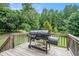 Back deck with an outdoor kitchen, BBQ, and views of the wooded backyard at 304 Bennett Farms Ct, Acworth, GA 30102