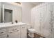 Clean bathroom featuring a white vanity with a coordinating toilet and shower with a floral curtain at 304 Bennett Farms Ct, Acworth, GA 30102