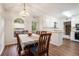 Dining room with hardwood floors adjacent to a kitchen with white cabinets at 304 Bennett Farms Ct, Acworth, GA 30102