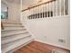 Cozy staircase with carpeted steps, a wooden railing, and hardwood floors below at 304 Bennett Farms Ct, Acworth, GA 30102