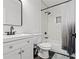 Well-lit bathroom with vanity, toilet, and shower-tub featuring stylish fixtures, decor, and tiling at 951 Reed Ave, Atlanta, GA 30344
