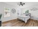 Bedroom featuring a bed with an upholstered headboard, wood floors, and three windows allowing ample sunlight at 951 Reed Ave, Atlanta, GA 30344