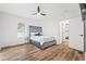 Bedroom with wood floors, large bed with headboard, ceiling fan, and doorway to another room at 951 Reed Ave, Atlanta, GA 30344