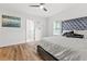 Bright bedroom features wood floors, ceiling fan, statement artwork, and a bed with an upholstered headboard at 951 Reed Ave, Atlanta, GA 30344