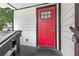 Close-up of a red front door with a glass pane, set against the white siding of a well-maintained house at 951 Reed Ave, Atlanta, GA 30344