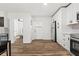 Modern kitchen with white cabinets, stainless steel appliances, wood floors, and open view to an adjacent room at 951 Reed Ave, Atlanta, GA 30344