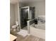 Modern bathroom with a glass-enclosed shower, soaking tub, and wood-look tile flooring at 4210 Chatham Ridge Drive Dr, Buford, GA 30518