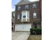 Charming brick townhome featuring a front entry garage and a well-maintained yard with lush greenery at 4210 Chatham Ridge Drive Dr, Buford, GA 30518