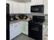 Functional kitchen with white cabinets, granite counters, and modern black appliances at 4210 Chatham Ridge Drive Dr, Buford, GA 30518