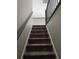 Carpeted staircase with modern black metal railing leads to the upper level of the home at 4210 Chatham Ridge Drive Dr, Buford, GA 30518