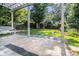 Inviting backyard patio with stone pavers, a pergola, bench seating, and manicured landscaping at 5575 Julian Pl, Atlanta, GA 30342