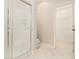 Bright bathroom view showing a glass enclosed shower, white tile flooring, and a walk-in closet at 5575 Julian Pl, Atlanta, GA 30342