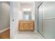 Well-lit bathroom featuring a wood vanity, a granite countertop, and a glass enclosed shower at 5575 Julian Pl, Atlanta, GA 30342