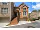 Inviting brick townhouse with a front-facing garage, and a welcoming front porch with stairs at 5575 Julian Pl, Atlanta, GA 30342
