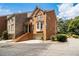 Brick townhouse with a two-car garage, mature landscaping, and a charming front entry at 5575 Julian Pl, Atlanta, GA 30342