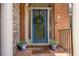 Close-up of a beautiful front door with decorative glass and a wreath, flanked by potted plants at 5575 Julian Pl, Atlanta, GA 30342