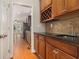 Elegant kitchen with wood cabinets, tile backsplash, black granite countertops, and stainless steel sink at 5575 Julian Pl, Atlanta, GA 30342
