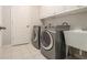 Convenient laundry room features a washer, dryer, utility sink, and storage cabinets at 5575 Julian Pl, Atlanta, GA 30342