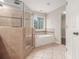 Elegant bathroom features large shower, soaking tub, and neutral tile at 5575 Julian Pl, Atlanta, GA 30342