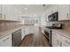 Modern kitchen featuring stainless steel appliances, white cabinets, and a stylish backsplash at 507 Bonneset Ct, Canton, GA 30114