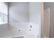 Bright bathroom featuring a tiled tub and a window bringing in natural light at 6207 Idlewood Cir, Lithonia, GA 30038