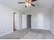 Carpeted bedroom with ceiling fan and three doors to different spaces at 6207 Idlewood Cir, Lithonia, GA 30038