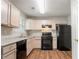 Well-lit kitchen with black appliances, light wood cabinets, and modern countertops at 6207 Idlewood Cir, Lithonia, GA 30038