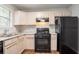 Well-lit kitchen with black appliances, light wood cabinets, and modern countertops at 6207 Idlewood Cir, Lithonia, GA 30038