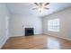 Spacious living room featuring a cozy fireplace, hardwood floors, and a ceiling fan at 6207 Idlewood Cir, Lithonia, GA 30038