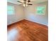 Bright bedroom featuring hardwood floors, a ceiling fan, and natural light from two windows at 1098 Laurel Nw Ln, Conyers, GA 30012