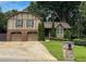 Charming home featuring a brick and siding exterior, attached two-car garage, and well-manicured lawn at 1280 Sanden Ferry Dr, Decatur, GA 30033