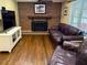 Gathering room featuring a brick fireplace, hardwood floors, and comfortable seating at 1280 Sanden Ferry Dr, Decatur, GA 30033