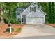 House exterior with two-car garage, light blue siding, and traditional design elements at 1420 Fieldgreen Overlook, Stone Mountain, GA 30088